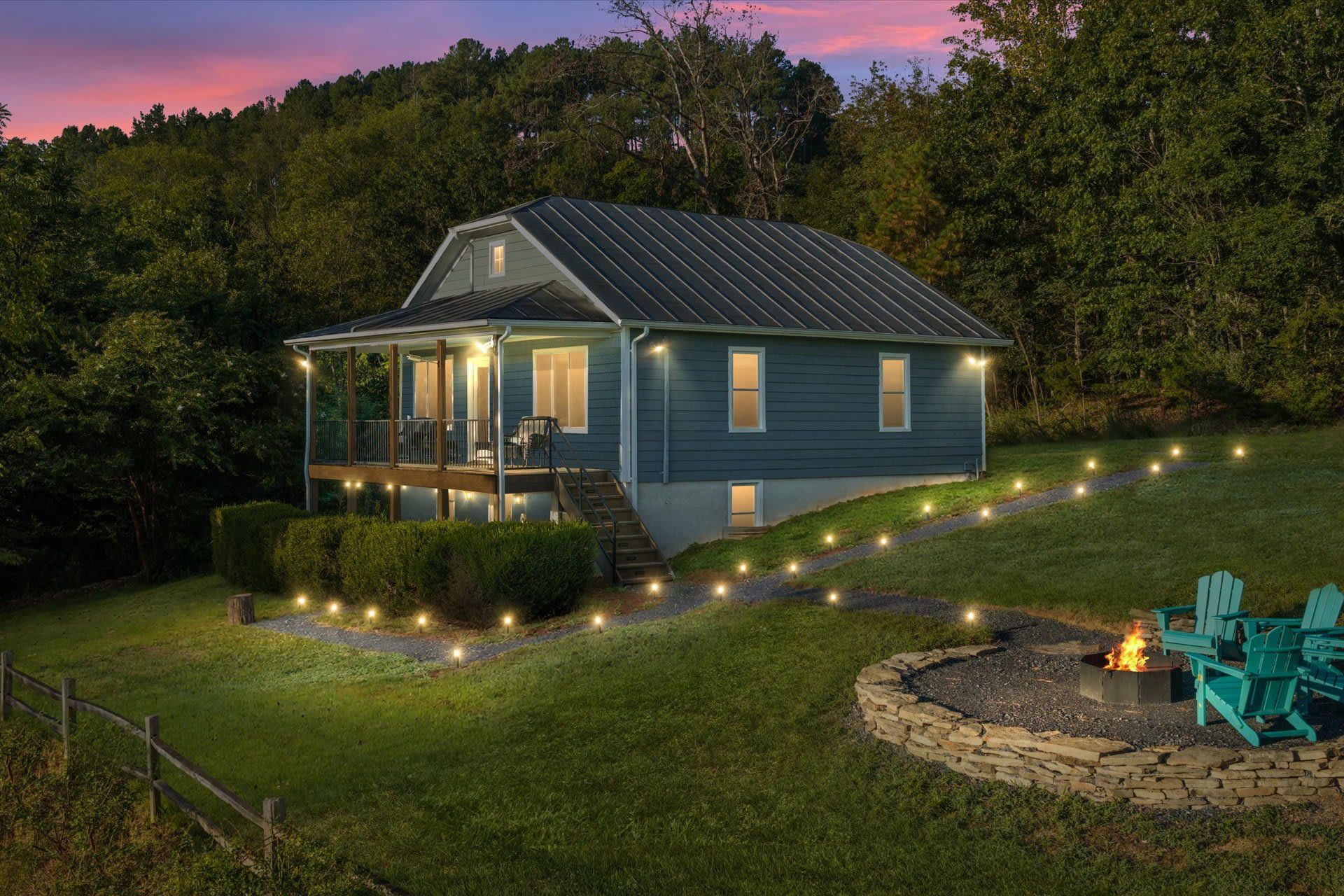 A house with a covered porch, a fire pit, and outdoor seating.