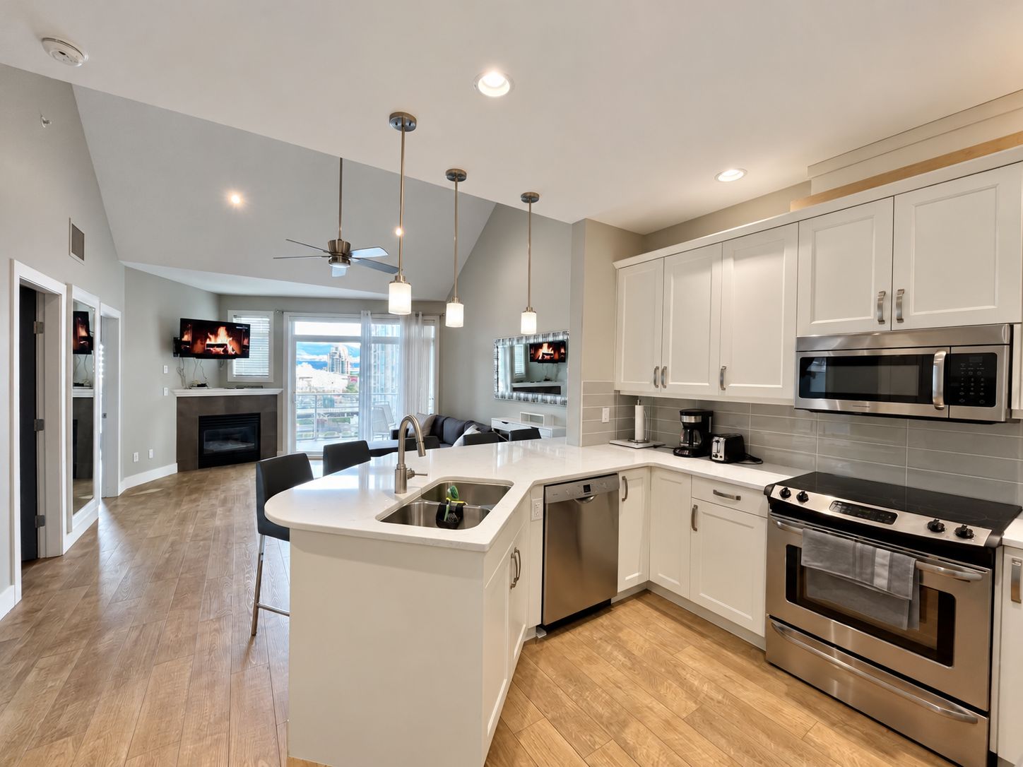A modern kitchen with white cabinetry, stainless steel appliances, and a central island.