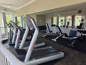 Een sportschool met loopbanden, gewichten en trainingsapparatuur.