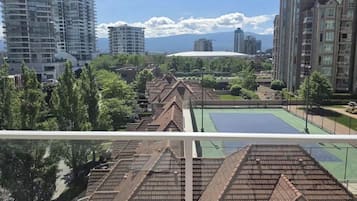 A residential area with high-rise buildings, a tennis court, and a large dome structure in the background.