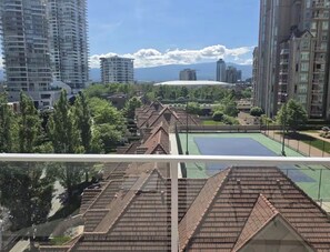 Een woongebied met hoge gebouwen, een tennisbaan en een grote koepelstructuur op de achtergrond.