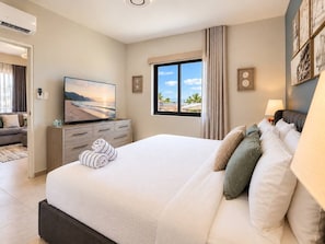 Une chambre à coucher avec un lit, une télévision, une fenêtre donnant sur un beau paysage et une table de chevet.
