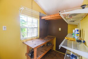 Ein kleiner, kompakter Raum mit Fenster, einer Holz-Werkbank und einer Wand mit Bohrlochleiste.