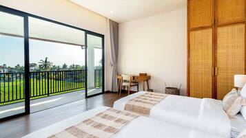 Habitación de hotel con balcón amplio, cama con ropa blanca, armario de madera y escritorio con silla.