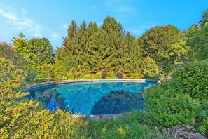 A clear blue swimming pool surrounded by dense greenery and trees. - Borgo Della Motta Swimming Pool &Golf, Travedona Monate, Italy (Travedona Monate)