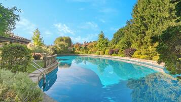 Una piscina limpida circondata da una vegetazione rigogliosa e un giardino curato.
