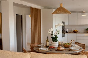 A dining area with a round table set for four, surrounded by wicker chairs. - Sanary Apt N2, Sanary-sur-Mer, France (Sanary-sur-Mer)