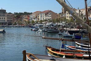 A marina with various boats docked, surrounded by buildings with balconies. - Sanary Apt N1, Sanary-sur-Mer, France (Sanary-sur-Mer)