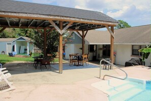A covered patio area with a pool, outdoor seating, and a small shed. - Spacious 4-bedroom house in fantastic Columbus with AC and gym access (Columbus)