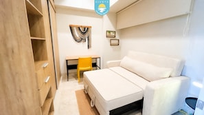 A compact room with a bed, a desk, and a chair. - Jacana Sunset 205 | Bucerias Beach & Rooftop Infinity Pool (Bucerias)