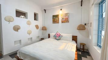 Un dormitorio con cama, ventana y adornos en la pared.