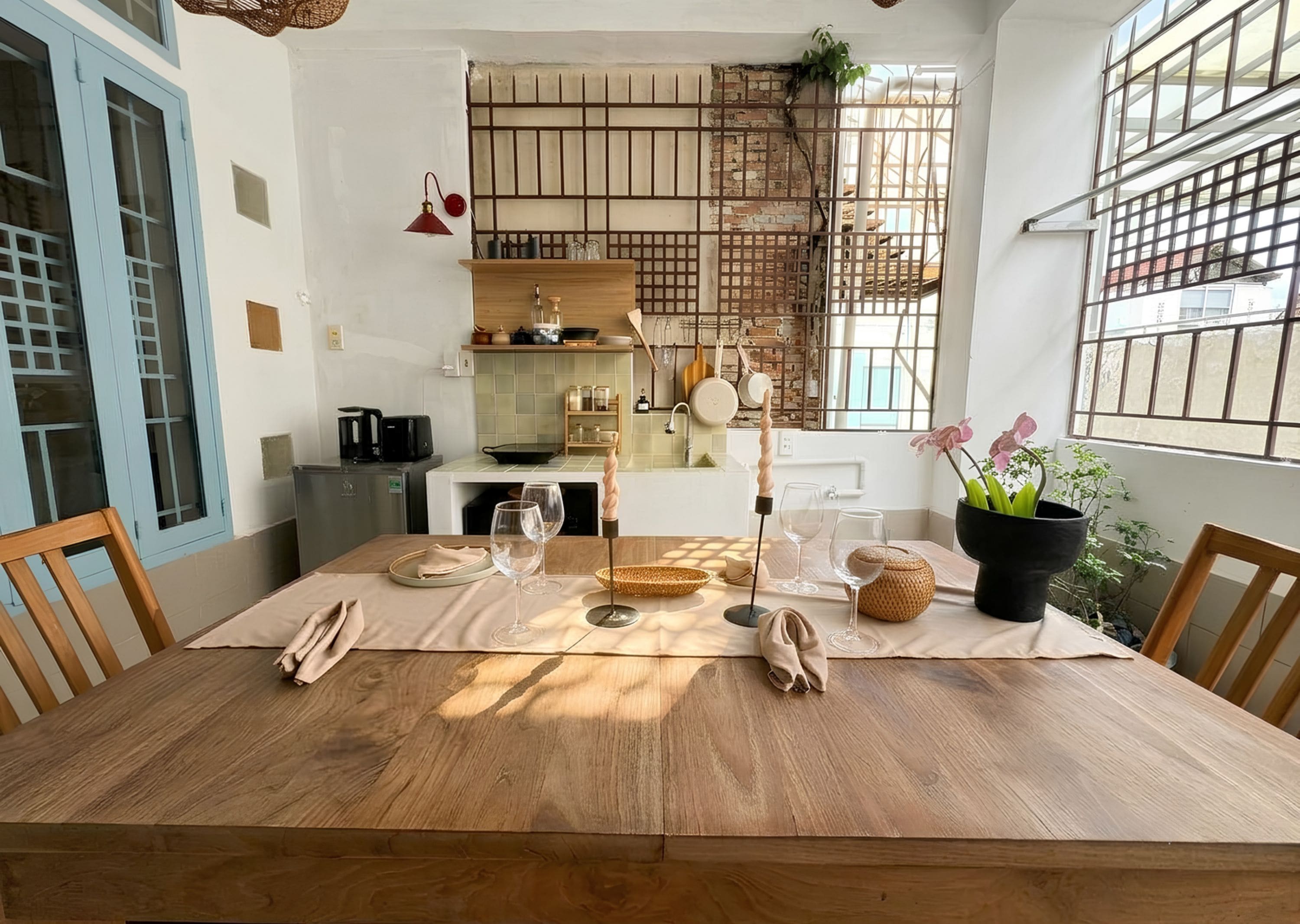 Un comedor con una mesa de madera, sillas y una planta en maceta.