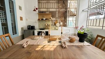Un comedor con una mesa de madera, sillas y una planta en maceta.