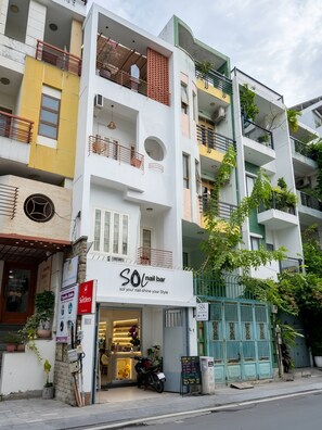 Un edificio de varios pisos con un salón llamado 'SOL nail bar' en la planta baja.