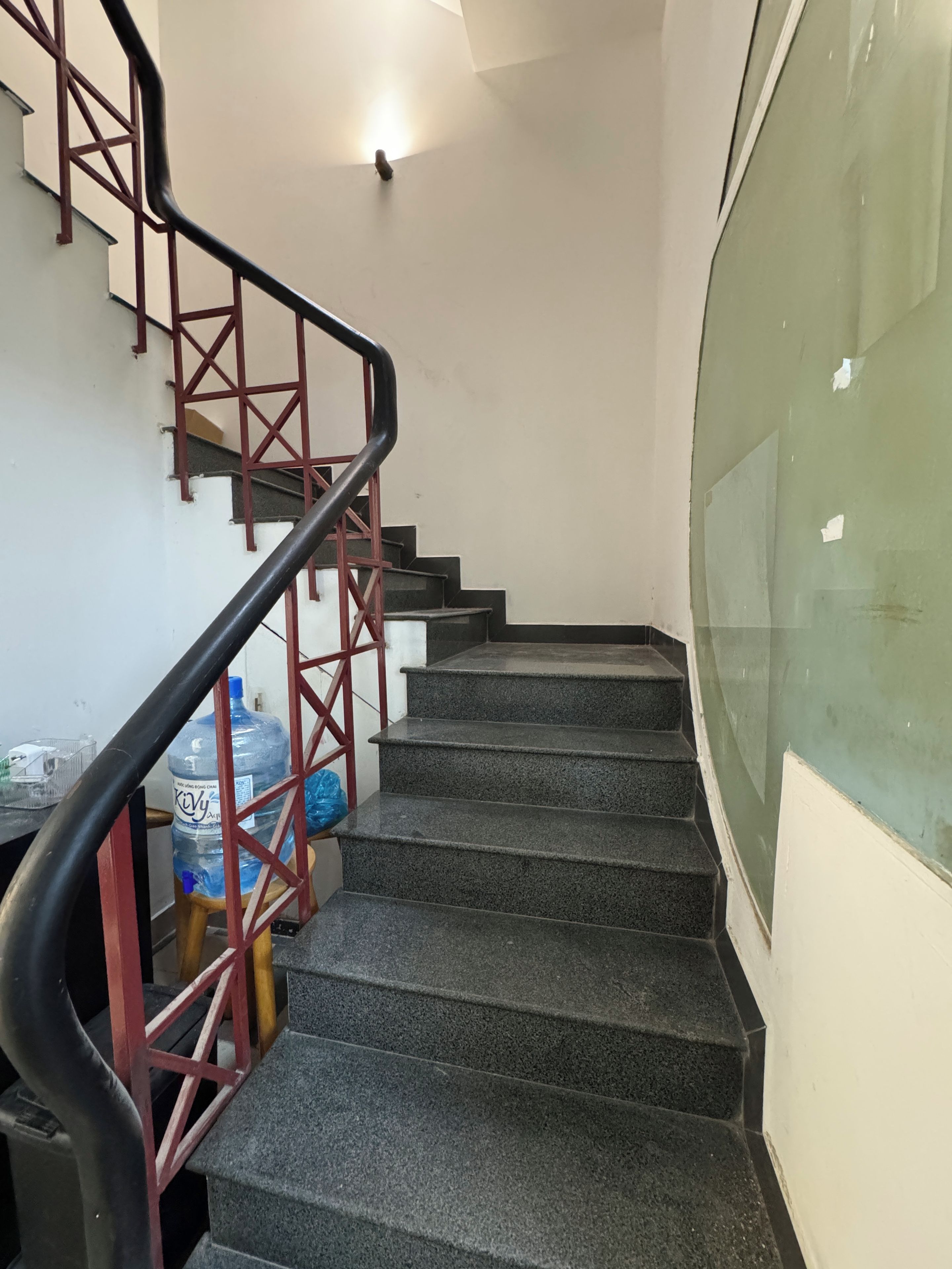 Una escalera con barandilla y un dispensador de agua al final.