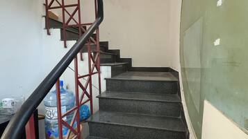 Una escalera con barandilla y un dispensador de agua al final.