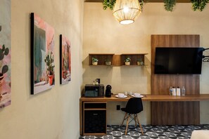 Un espacio habitable compacto con kitchenette, televisión de pantalla plana y comedor.