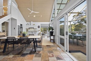 A modern kitchen with a dining area, large windows, and a ceiling fan. - Sullivan's Loft (Sorrento)