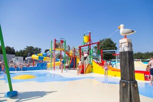 Un parque acuático con una estructura de juegos y una estatua de gaviota.