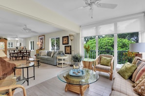 A spacious living area with a balcony, a dining area, and a kitchen. - Olde Naples Getaway | 2BR Condo Near Beach & 3rd Ave S (Naples)