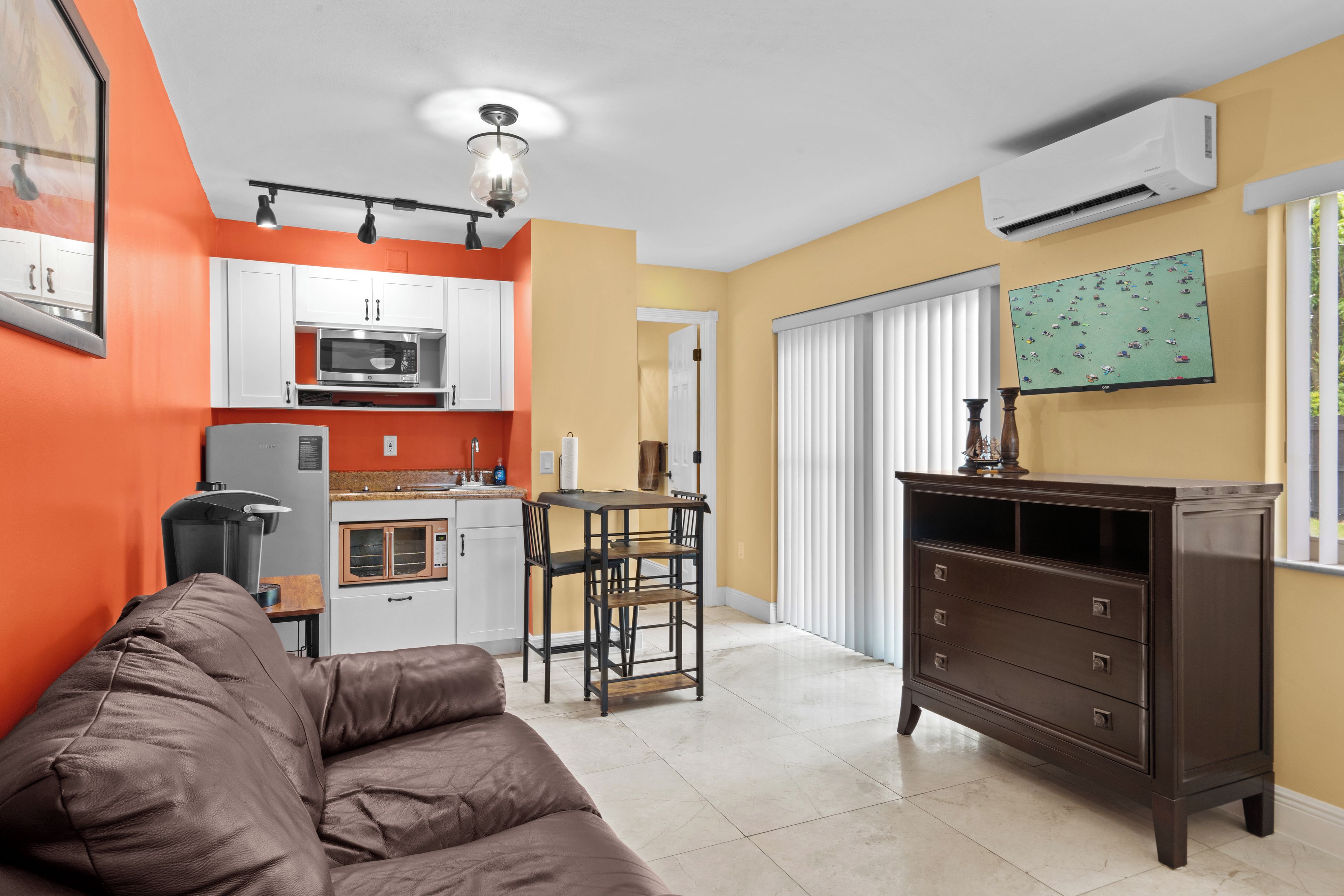 A compact living space with a kitchenette, a dining area, and a seating area.