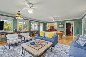 A spacious living room with a pool table, a blue sofa, and a coffee table. - Cedar Vista | Mt. Yonah Views & Pool Table (Sautee Nacoochee)
