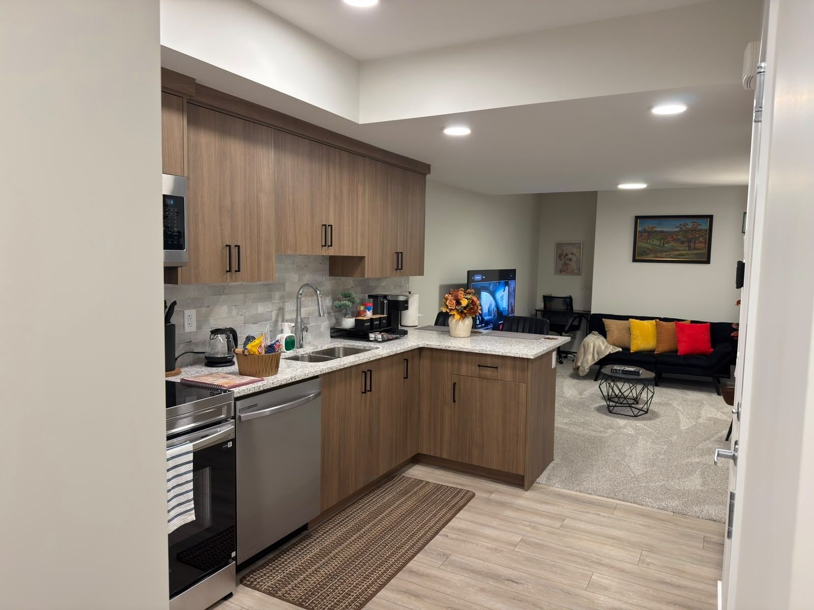 A modern kitchen with wooden cabinets, stainless steel appliances, and a central island.