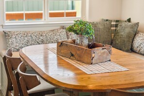 Ein Holztisch mit einem Blumentopf in der Mitte, umgeben von Stühlen.