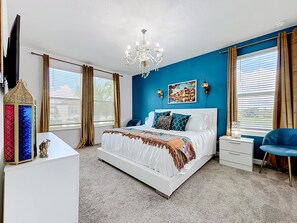 Une chambre à coucher avec un grand lit, un lustre, une télévision et une lanterne décorative.