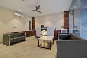 Un área de espera moderna con un sofá, una mesa y un ventilador de techo.