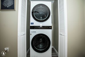 Lavadora y secadora apiladas en un cuarto de lavado.