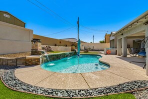 A backyard with a swimming pool, stone border, and outdoor seating area. - Havasu Sahara - Pool, BBQ, Cozy Living Space (Lake Havasu City)