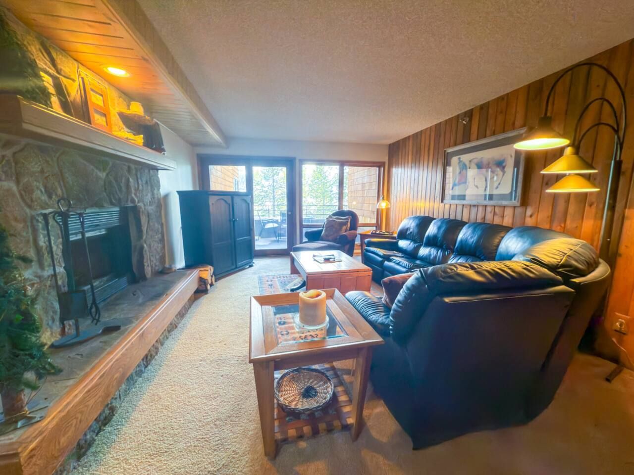 A cozy living room with a fireplace, leather sofa, and a coffee table.