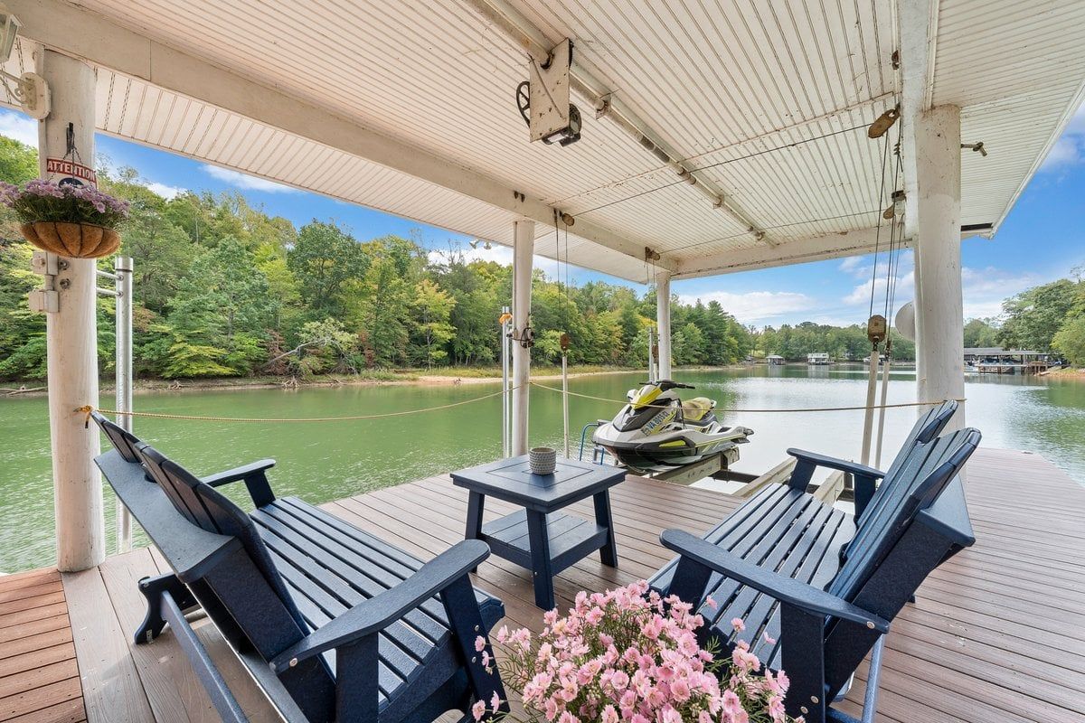 An outdoor deck with two chairs, a table, and a jet ski.