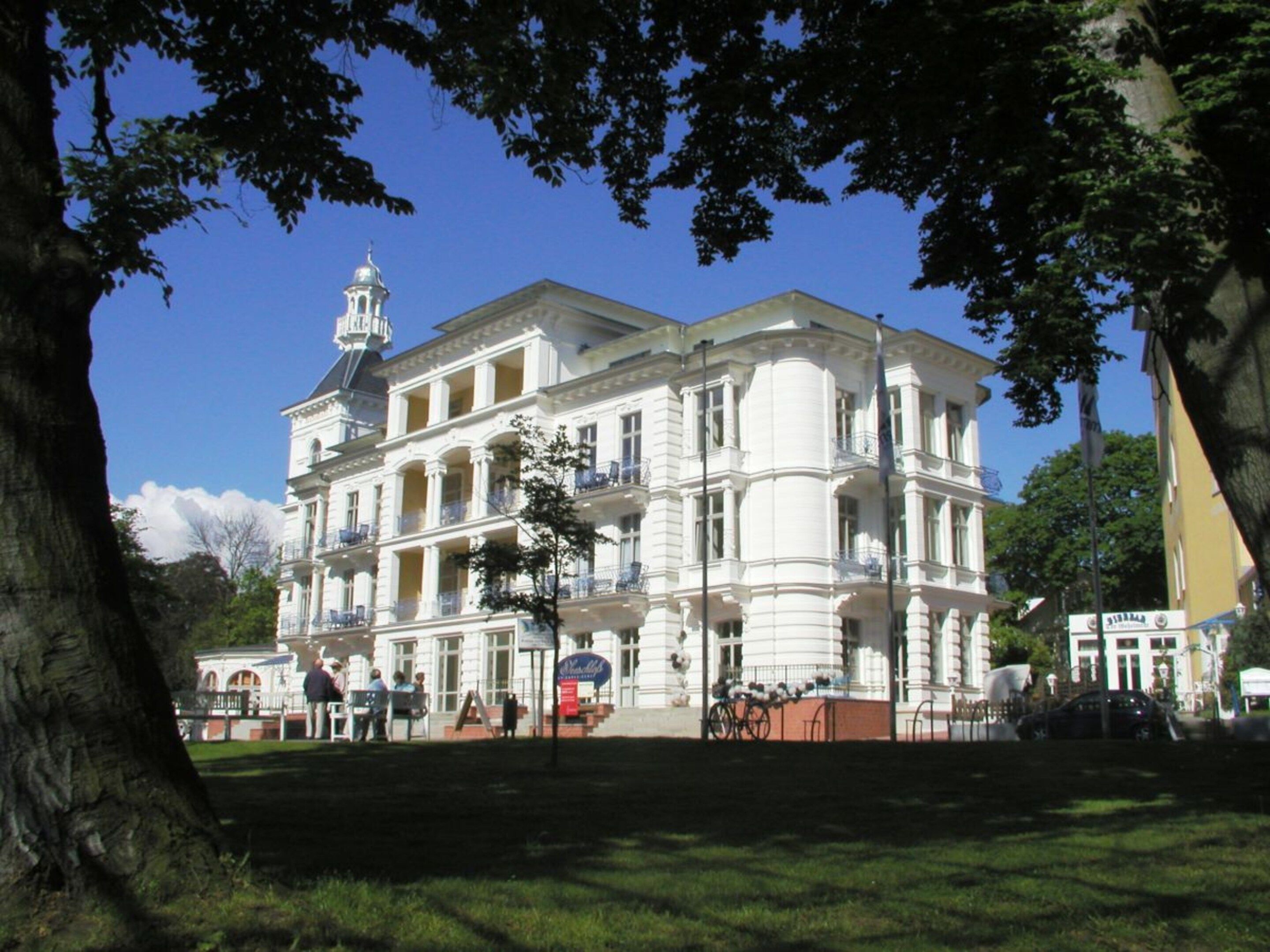 A multi-story building with a classical architectural style, featuring a prominent central tower and multiple balconies.