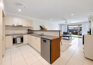 A modern kitchen with a dishwasher, oven, and a coffee machine. - Caloundra Townhouse  2 bed, 2 bath, 2 car, 5 mins to beaches. Private (Caloundra West)