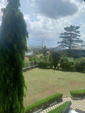 A grassy area with a tree and a fence. - Pearl On The Nile Hotel Jinja (Jinja)
