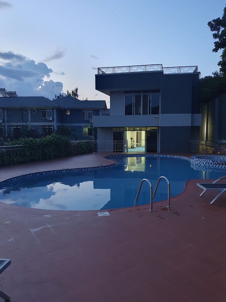 Zona de piscina con un edificio al fondo.