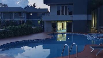 Zona de piscina con un edificio al fondo.