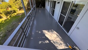 A balcony with a metal railing, a flat surface, and a view of trees and grass. - Lake & Sky Metung – Best Views, Walk to Beach, Hot Springs & Town (Metung)
