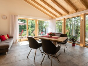 Ein stilvoller Essbereich mit Holztisch, Stühlen und Blick ins Freie.