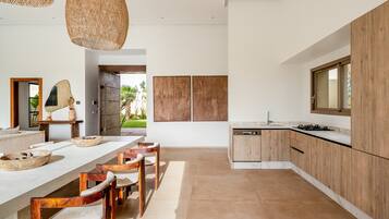 A modern kitchen with a central island, wooden cabinets, and a large window.