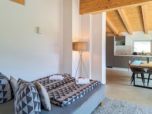 A modern living room with a sofa, a floor lamp, and a view into a kitchen area. - Adlerhorst by Interhome (Auffach)