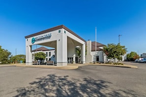 A gas station with a canopy labeled 'CLARION INN' and a building with a brown roof in the background. - Fun-Filled Cranberry Stay | 2 Bedrooms & Free Full Breakfast (Cranberry Township)