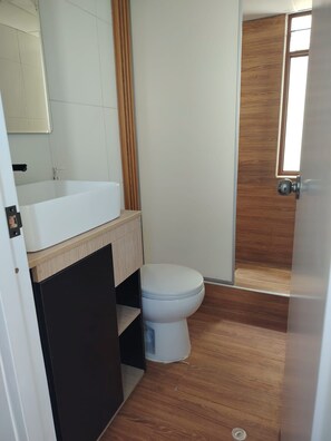 A bathroom with a white toilet, a wooden vanity, and a mirror above the sink. - 4 bedrooms · View of the Cordillera Blanca · La Soledad (Huaraz)