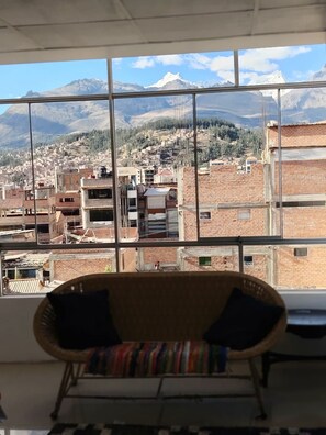 A room with a large window overlooking a mountainous landscape and a cityscape. - 4 bedrooms · View of the Cordillera Blanca · La Soledad (Huaraz)