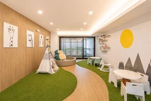 A children's playroom with a tent, a rocking horse, and a round table. - Moderno Loft en Malecón Piscina Gym (Lima)