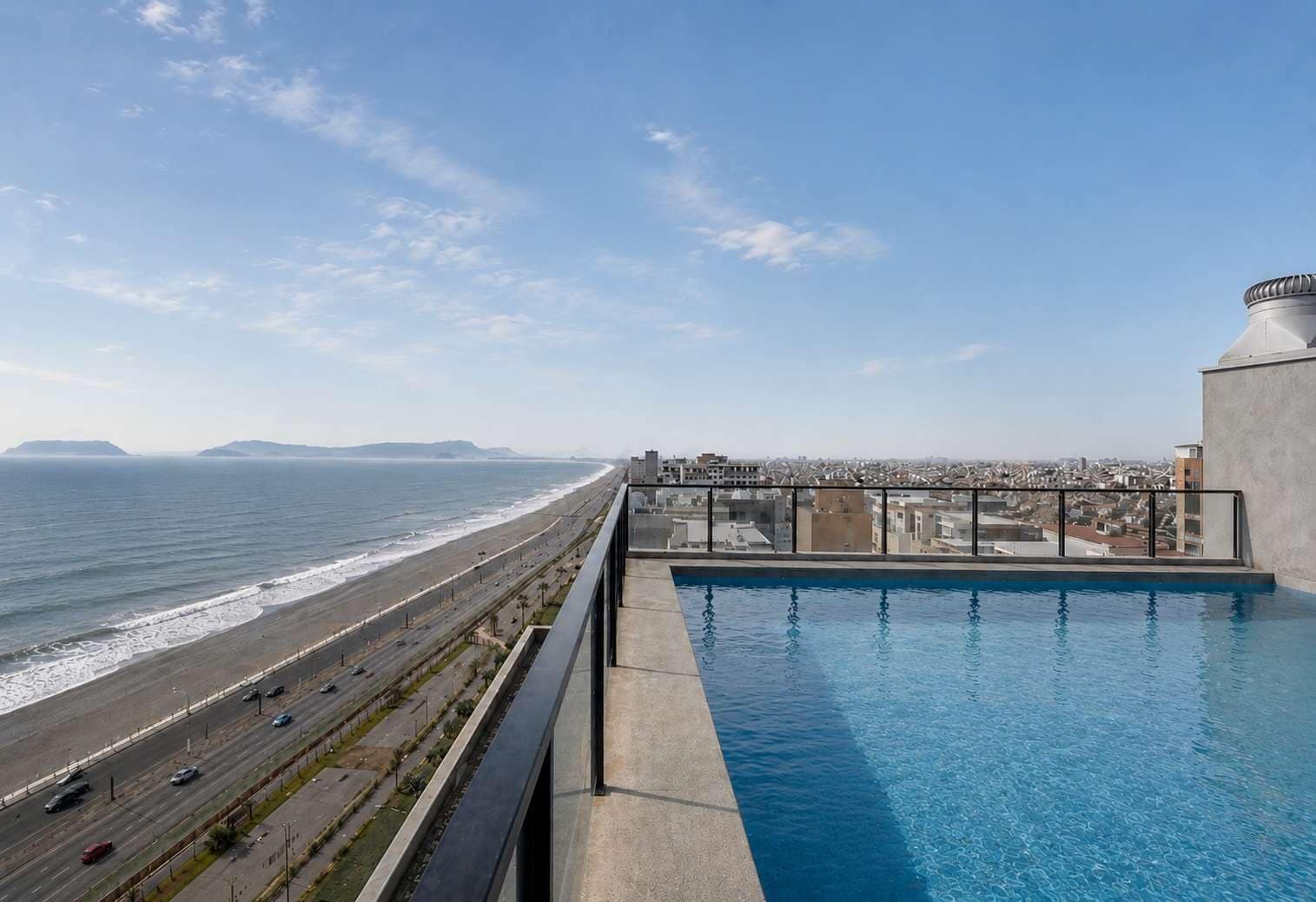 Una piscina en la azotea con vistas a la playa y al paisaje urbano.