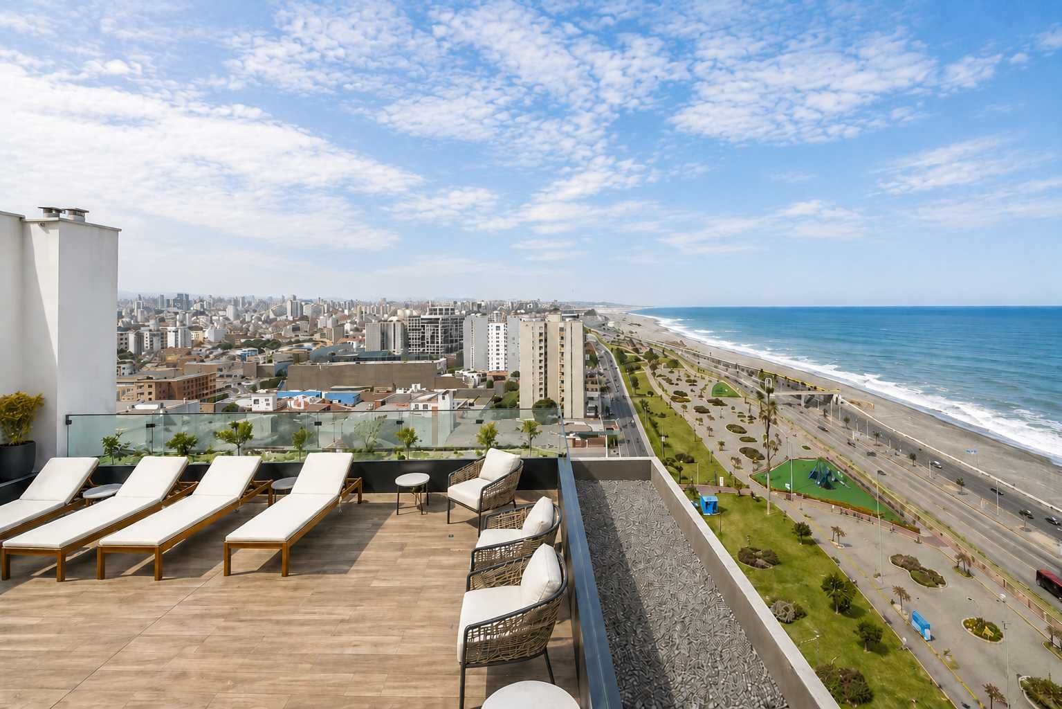 Una terraza en la azotea con tumbonas, vistas a la ciudad y al océano.