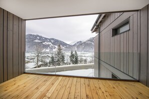A room with a large glass window offering a view of snow-covered mountains and a wooden floor. - Apartment With Sauna Near ski Resort (Hollersbach im Pinzgau)